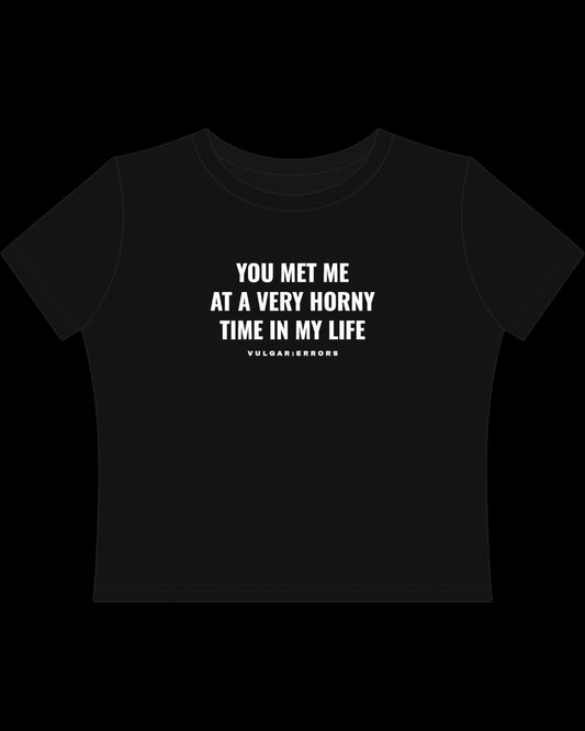 Back view of fitted black baby tee showing cropped shape, short sleeves, and clean cotton finish