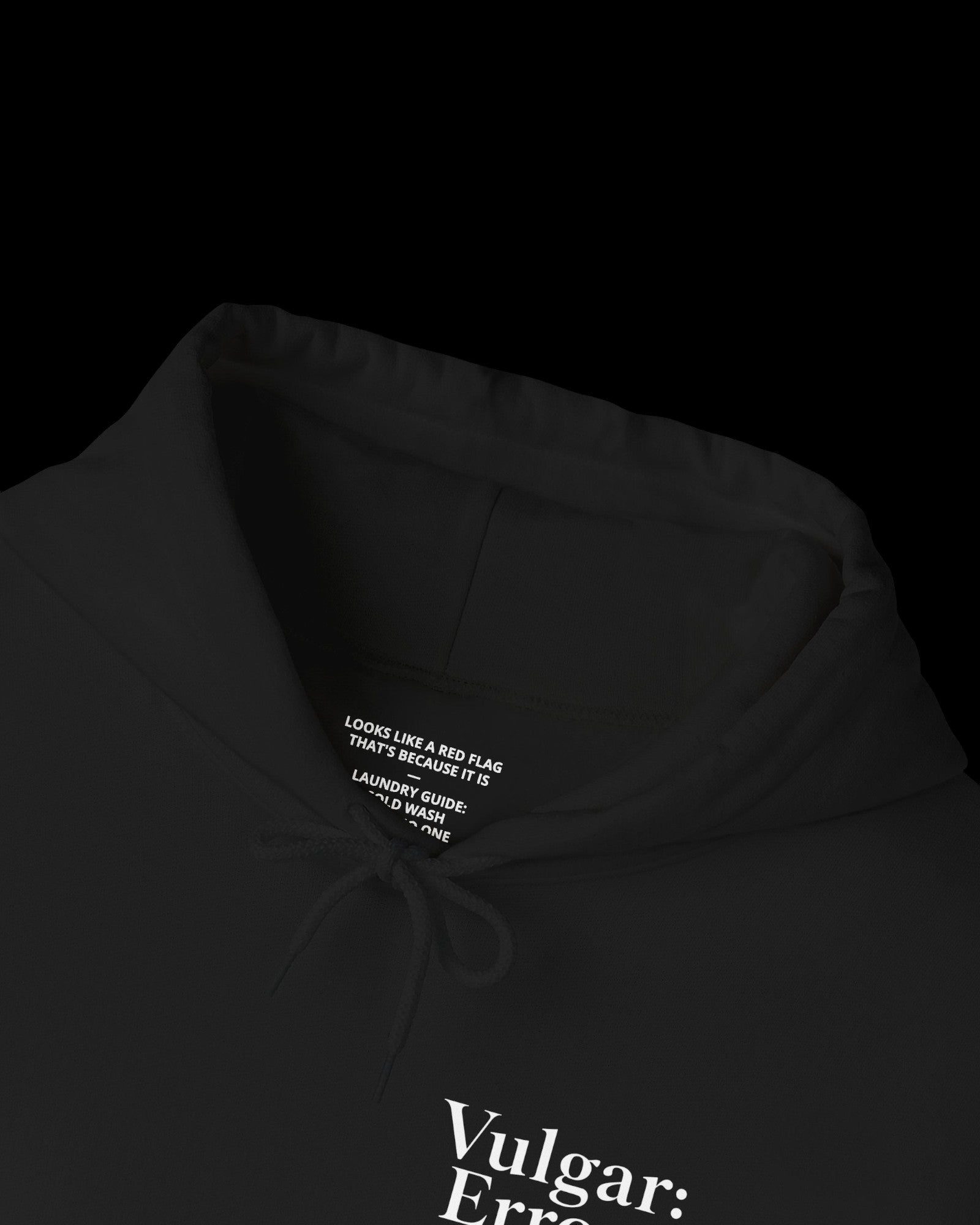 Inner neck label of black hoodie showing printed care guide, size, and cotton fabric details