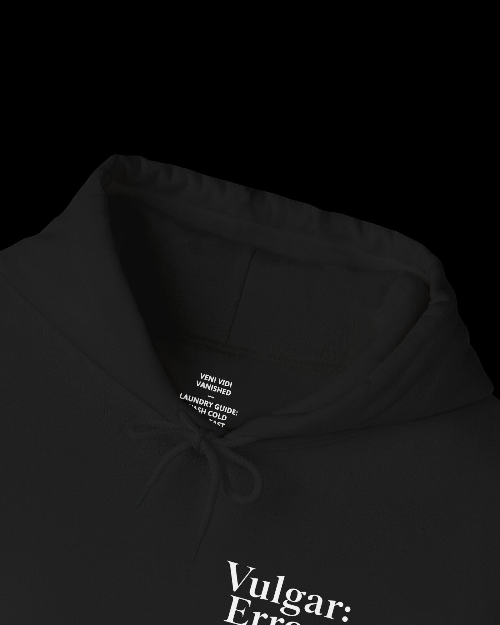 Inner neck label of black hoodie showing printed care guide, size, and cotton fabric details
