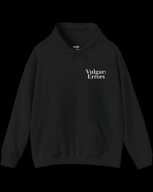 Inner neck label of black hoodie showing printed care guide, size, and cotton fabric details