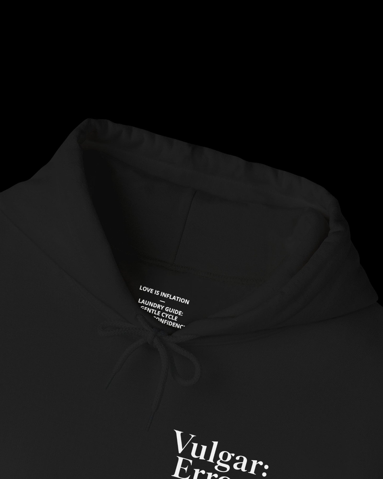 Inner neck label of black hoodie showing printed care guide, size, and cotton fabric details