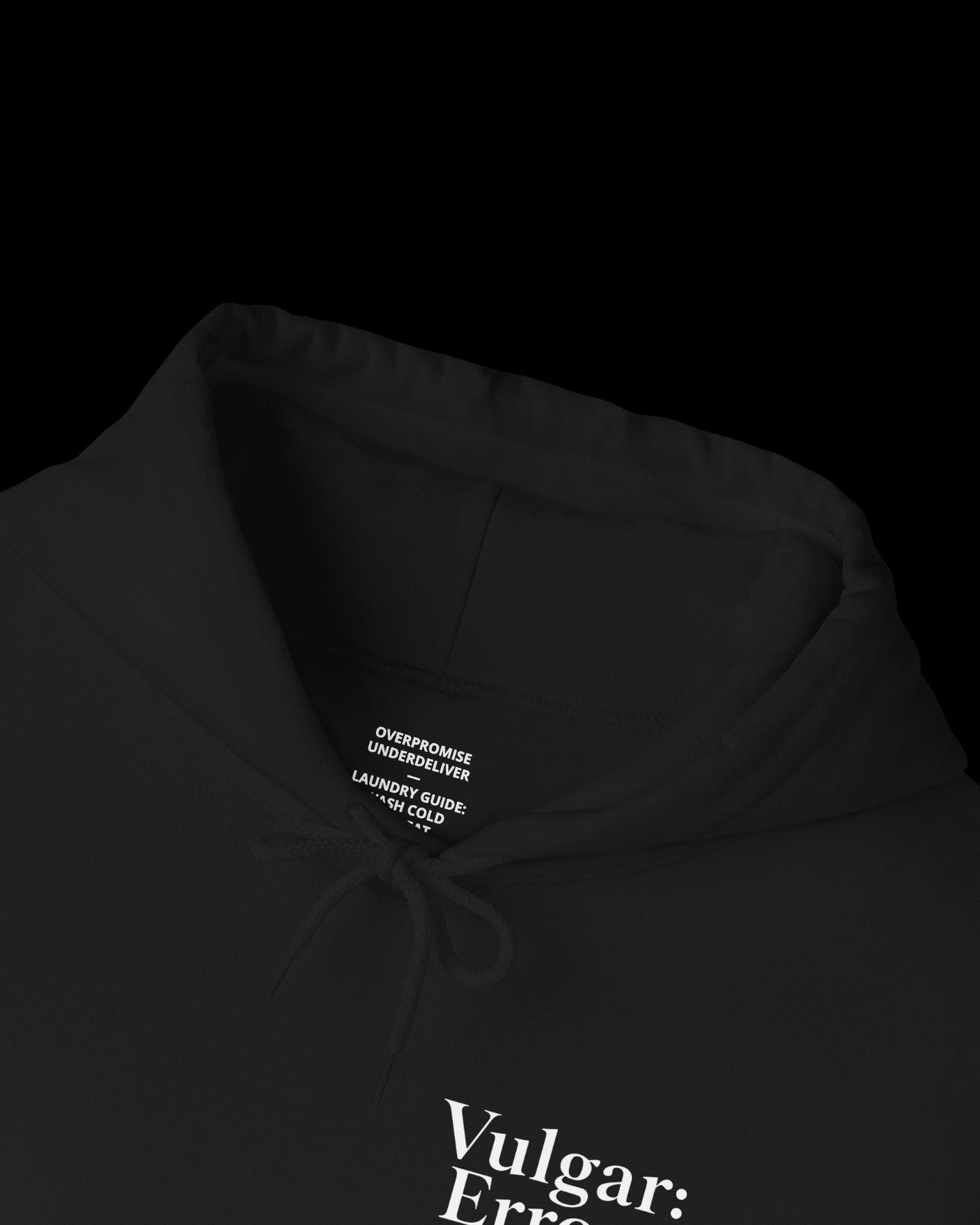 Inner neck label of black hoodie showing printed care guide, size, and cotton fabric details