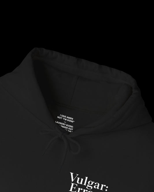 Inner neck label of black hoodie showing printed care guide, size, and cotton fabric details