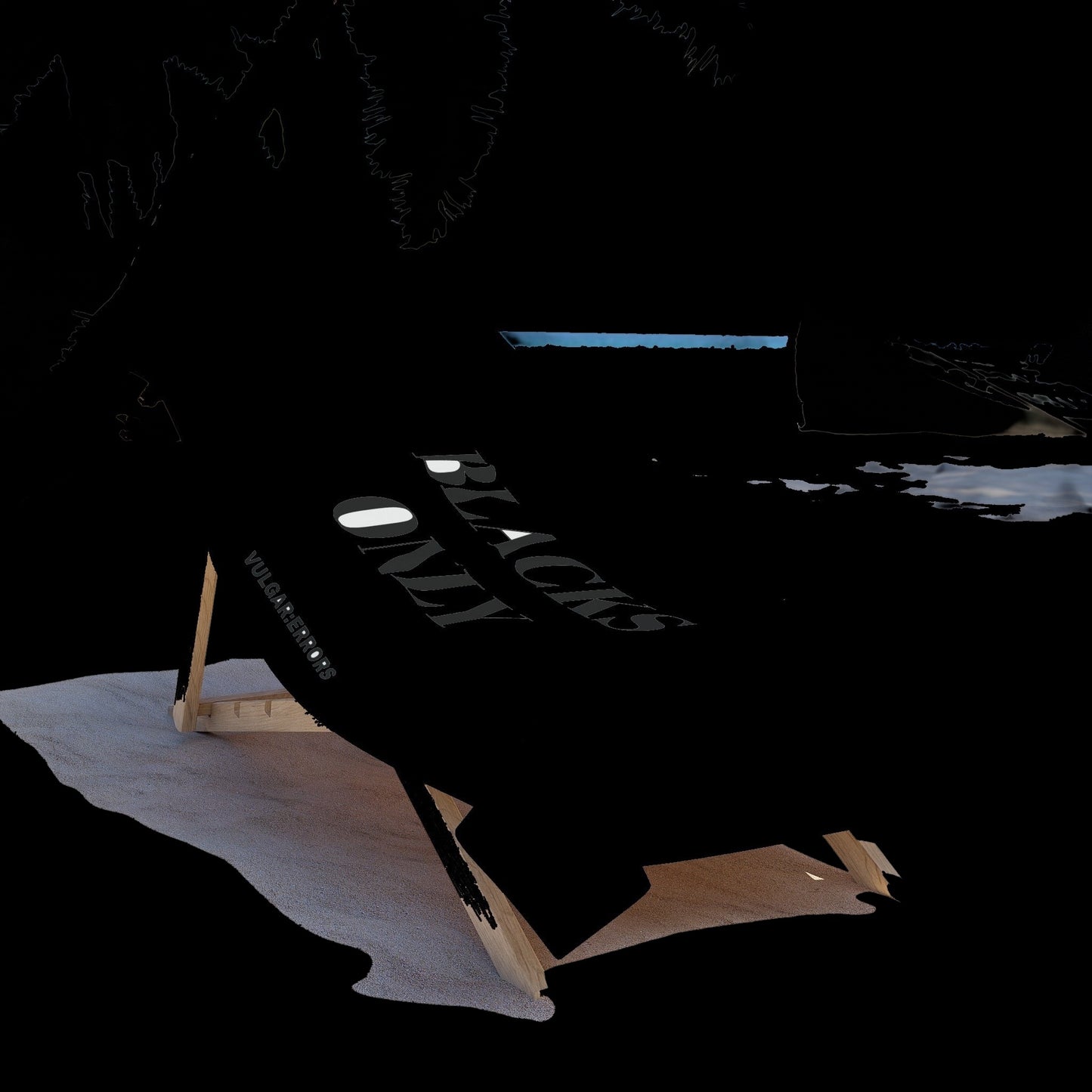 Vulgar Errors oversized black beach towel with bold white text draped over a wooden lounge chair on a sandy beach.
