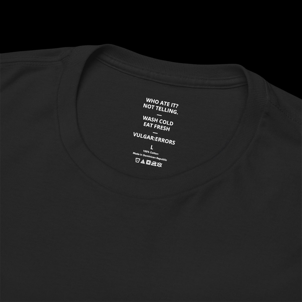 Vulgar Errors black cotton tee featuring a printed inner neck label with typographic care instructions and branding.